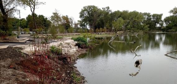 Photo of pond at West Ridge Nature Park with green trees in the background