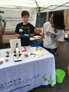 NU graduate neuro students at a table showing off brain slices with a microscope